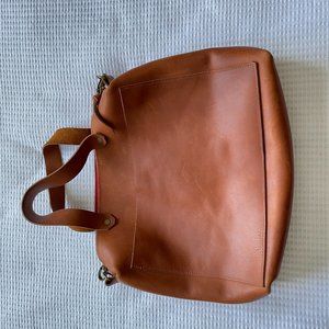 Crossbody raw leather handbag in Cognac.